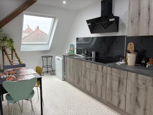 a kitchen with a counter and a table with chairs at Gîte le Nid in Uffholtz