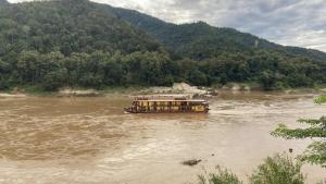 a boat in the middle of a river at Mekong Backpackers 2 PB in Pakbeng