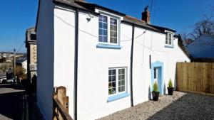 una casa bianca con finestre sul lato di North Cornwall 2-Bed Detached Period Cottage With Parking a Camelford