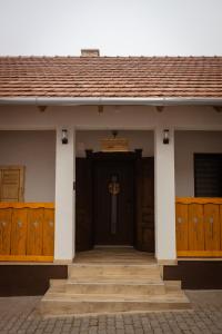 a house with a wooden door and wooden stairs at Lebujos Vendégház in Boldogkőváralja