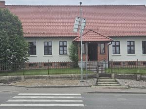 a white house with a red roof and a crosswalk at Plebanka in Grabowo