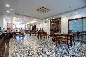 um restaurante com mesas e cadeiras e pessoas a comer em Luxe Paradise Premium Hotel Nguyen Khac Hieu em Hanói