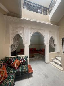 Riad Nora - Confort, Calme & Sécurité في مراكش: غرفة معيشة مع أريكة ومدفأة