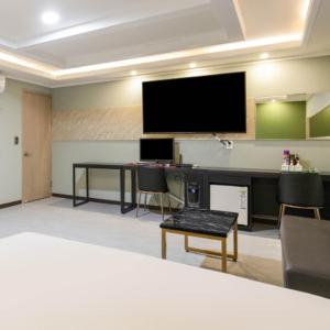a conference room with a desk and a flat screen tv at 와이케이호텔 in Suwon
