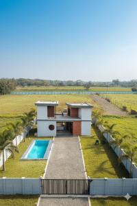 une maison avec une piscine dans un champ dans l'établissement KASA FARM stay, à Radjahmoundry