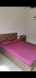 un grand lit avec une couverture rose dessus dans l'établissement KASA FARM stay, à Radjahmoundry 2 autres photos