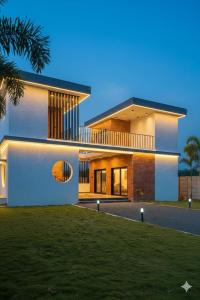 une grande maison avec des lumières sur son côté dans l'établissement KASA FARM stay, à Radjahmoundry