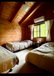 a bedroom with two beds and a window at 蔵王ペンション kobaya in Kaminoyama