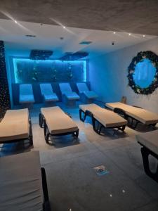 a waiting room with tables and chairs and an aquarium at Apartman Lakers in Ostrovo