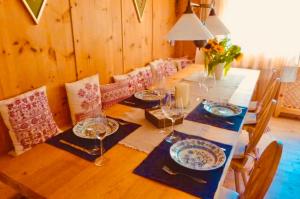 a wooden table with plates and wine glasses on it at Haus Freistabl in Sölden