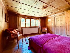 a bedroom with a bed and two chairs in a room at Haus Freistabl - Uriges Bauernhaus für 6 Personen mit Sauna & Bergblick im Ötztal in Sölden