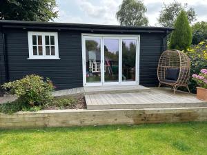 a tiny house with a porch and a chair at Peaceful Garden Cottage in Birmingham