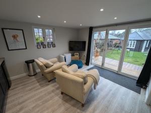 a living room with couches and a large window at Peaceful Garden Cottage in Birmingham