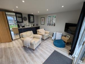 a living room with two chairs and a flat screen tv at Peaceful Garden Cottage in Birmingham