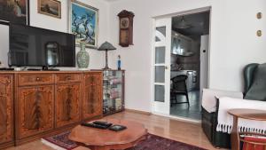 a living room with a television on a wooden entertainment center at Big & Bright City Center Apartment in Užice