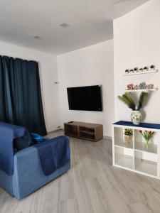 a living room with a blue couch and a flat screen tv at Alisea Home in Nerano