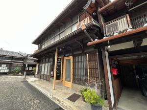 um edifício antigo com um sinal na parte da frente em 宿場を眺める古民家宿陽屋-Hinataya- em Nakatsugawa