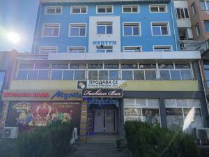 a large blue building next to a building at Neptun Apartments in Veliko Tŭrnovo