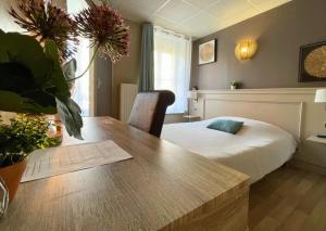une chambre avec un lit et une table avec une table sidx sidx dans l'établissement La Pause Voyage - chambre privative, gare à proximité, à Bourbourg 7 autres photos