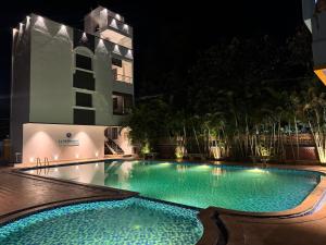une piscine devant un immeuble la nuit dans l'établissement La Millionaire Resort, à Auroville