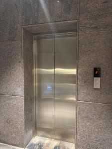 un ascenseur en acier inoxydable dans un immeuble dans l'établissement La Millionaire Resort, à Auroville