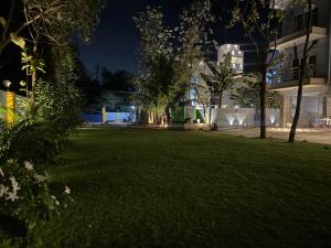 un parc de nuit avec des arbres et un bâtiment dans l'établissement La Millionaire Resort, à Auroville