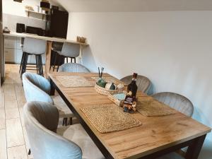 een houten tafel met stoelen en een fles wijn erop bij Rzeczny Zakątek in Zawoja