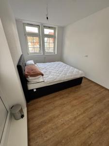 a small bedroom with a bed and two windows at PRV Apartment 2 in Künzelsau