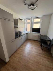 a kitchen with white cabinets and a table and chairs at PRV Apartment 2 in Künzelsau