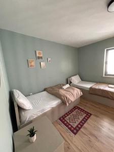 a small room with two beds and a rug at Itan’s apartments in Tirana