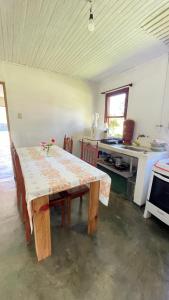 Zimmer mit einem Tisch und einer Küche mit einer Theke in der Unterkunft casa descanço in Gonçalves + 10 Fotos