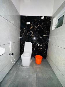 a bathroom with a white toilet and a sink at AZURE stay happy in Pudunagaram