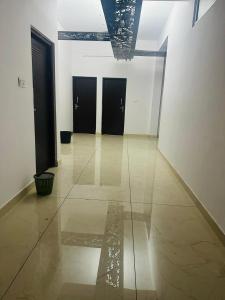 a hallway with black doors and a tile floor at AZURE stay happy in Pudunagaram