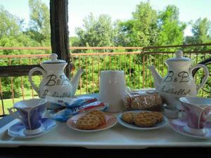 a table with two tea pots and cookies on it at B&B La Libellula in Pratella