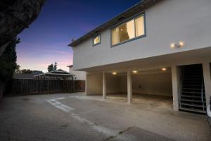 ein großes weißes Haus mit Parkplatz in der Unterkunft Modern 2BR Unit with Covered Parking in Santa Clara apts in Santa Clara