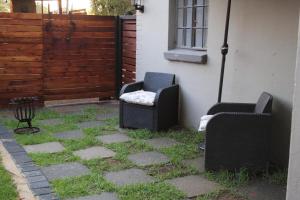 two chairs sitting on the side of a house at Cottage of Grace in Benoni