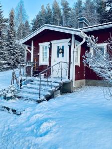 una casa rossa con la neve davanti di Villa Oinas a Tervola Altre 24 foto