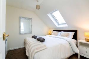ein Schlafzimmer mit einem großen weißen Bett und einem Fenster in der Unterkunft 4 Bedroom Townhouse In Stirling in Stirling
