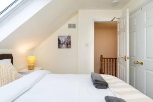 ein weißes Schlafzimmer mit einem weißen Bett und einer Tür in der Unterkunft 4 Bedroom Townhouse In Stirling in Stirling + 24 Fotos