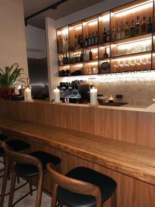 Un bar con sillas y botellas en la pared. en Door9 Hasselt - Digital Hotel & Bar, en Hasselt
