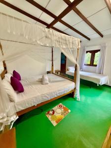 a bedroom with two beds and a green floor at Thusitha s nest in Dickwella