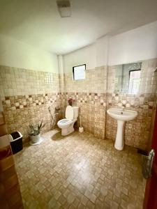 a bathroom with a toilet and a sink at Thusitha s nest in Dickwella