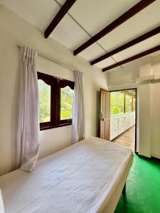 a bedroom with a large white bed with a window at Thusitha s nest in Dickwella