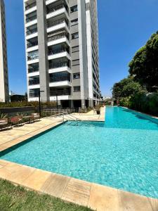 グアルーリョスにあるGiardino Maia, Café da Manhã cortesia em dias úteisの高層ビルの前の大型スイミングプール +20枚の写真