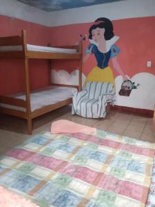 een slaapkamer met stapelbedden met een muurschildering van een Disney-prinses bij Hostal Zope in Cataltzul