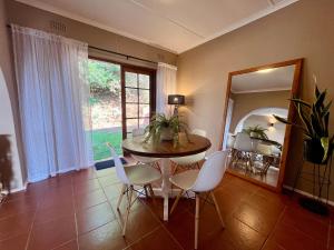 a dining room with a table and chairs and a mirror at Casa Bellé Bluff in Durban