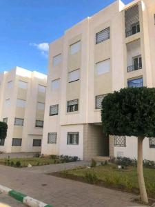 un grande edificio bianco con un albero di fronte di Gravereau a Oujda