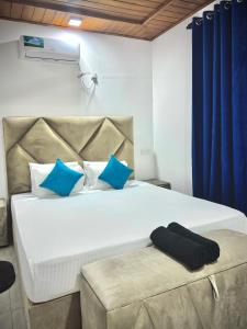 una camera da letto con un grande letto bianco con cuscini blu di Apartment W Kitchen 5 Mins Beach 20 Mins Airport a Negombo