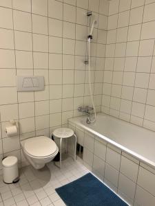 a bathroom with a toilet and a tub and a sink at City home in Tromsø +1 photo