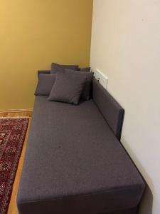 a bed with purple pillows in a room at City home in Tromsø